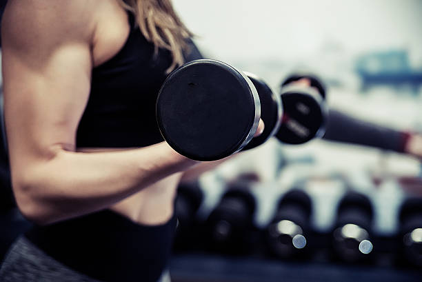 istock athletic woman pumping up muscles with dumbbells 638008812