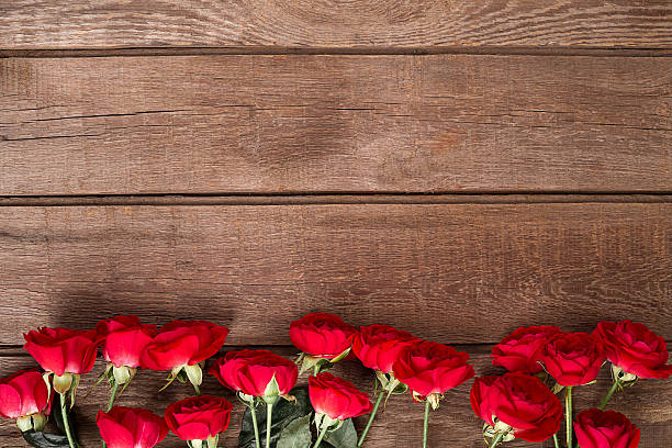 istock Red roses bouquet over wooden table. Top view with copy 638009914