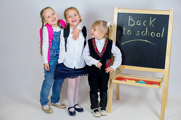 istock three young schoolgirls near the blackboard 638011746