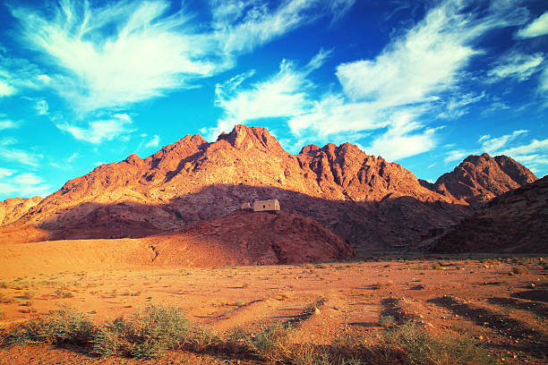 House on hill in desert next to mountain. Beautiful landscape. House on hill in desert next to mountain. Beautiful cloudscape and landscape. Neighborhood of Saint Catherine and Mount Moses in Sinai Egypt. Tinted toned coloration image mt sinai stock pictures, royalty-free photos & images