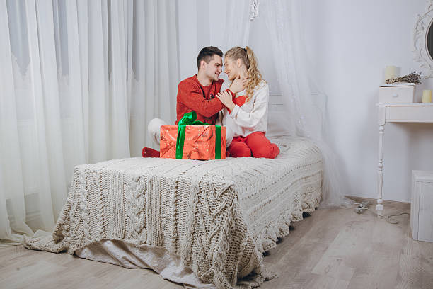 couple aimant décorer l’arbre de noël - placard holding celebration women photos et images de collection