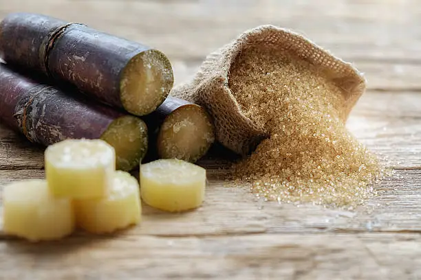brown cane sugar with sugarcane  on wooden background soft focus,selective focus.