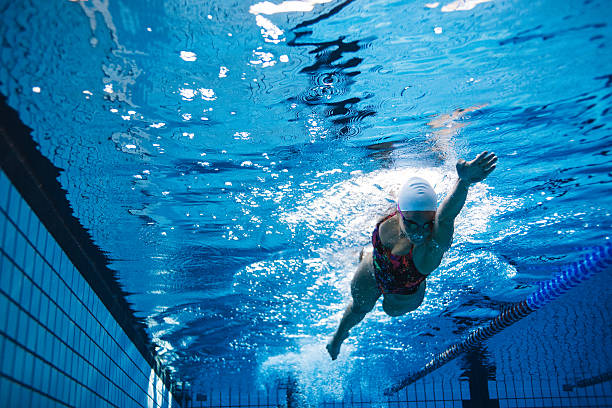 fit sportlerin schwimmen im pool - schwimmen fotos stock-fotos und bilder