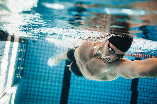 Fit swimmer training in the swimming pool Fit swimmer training in the swimming pool. Professional male swimmer inside swimming pool. jacob ammentorp lund stock pictures, royalty-free photos & images