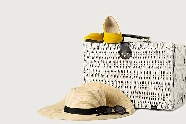 istock White wicker suitcase, womens hat, sunglasses and yellow shoes. 638024984