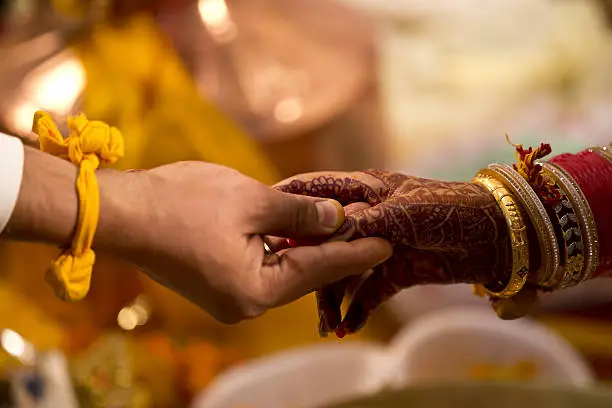 Indian bride and groom holding hands during wedding ceremony