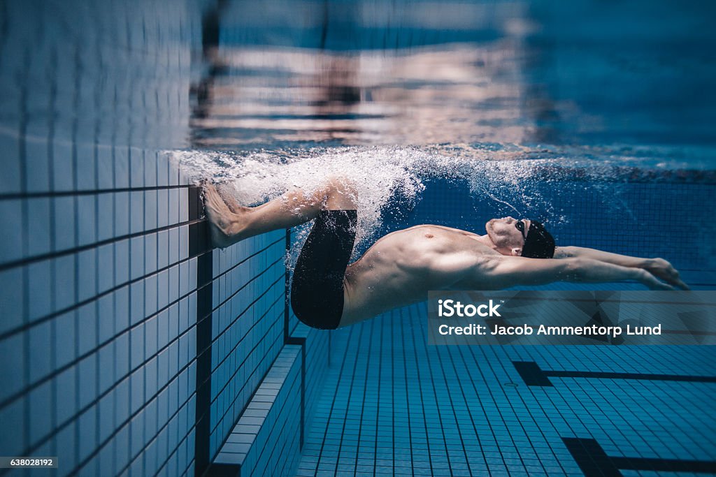 Nuotatore professionista in azione all'interno della piscina - Foto stock royalty-free di Nuoto