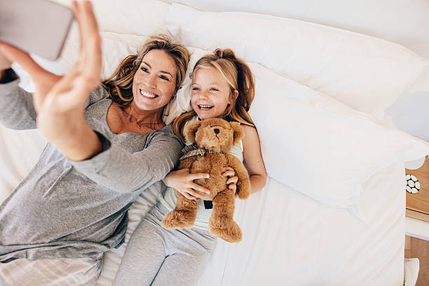 istock Young family taking selfie with smartphone in bed 638029038