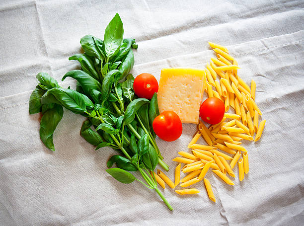 istock Basil, tomatoes, parmesan and raw pasta penne on gray tablecloth 638029282