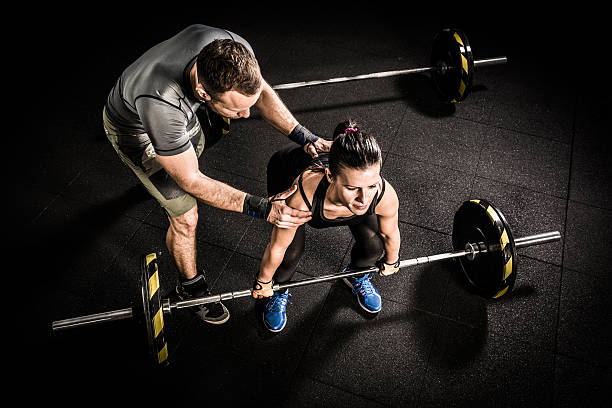 ジムでのクロストレーニングの若い女性とフィットネスインストラクター - weightlifting crossfit weight training men ストックフォトと画像