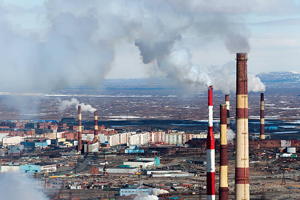 Smoking factory chimneys in the background of the city. stock photo