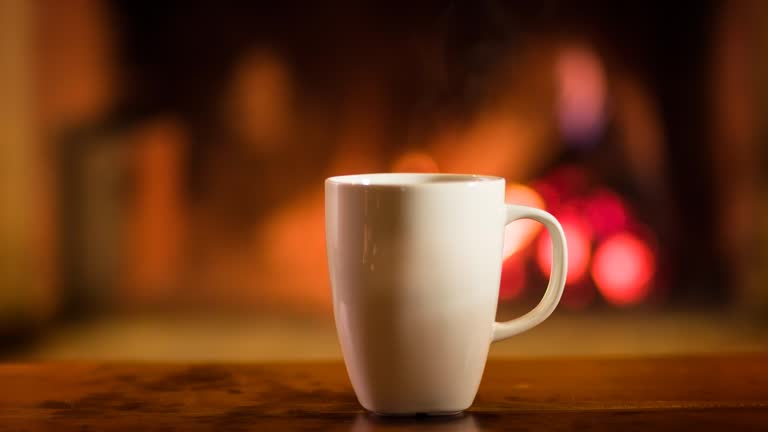 Cup of hot beverage in front of a fireplace