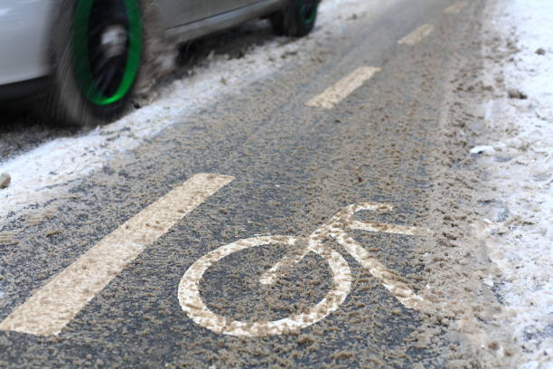 istock snow-capped bike path and a partial view of a car 638048350