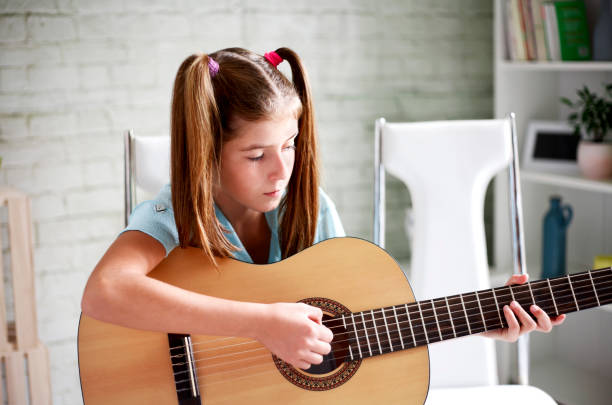 istock Girl learns to play guitar 638049342