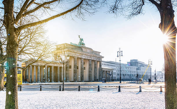 blick auf das berliner brandenburger tor mit schnee in der morgensonne - brandenburger tor stock-fotos und bilder