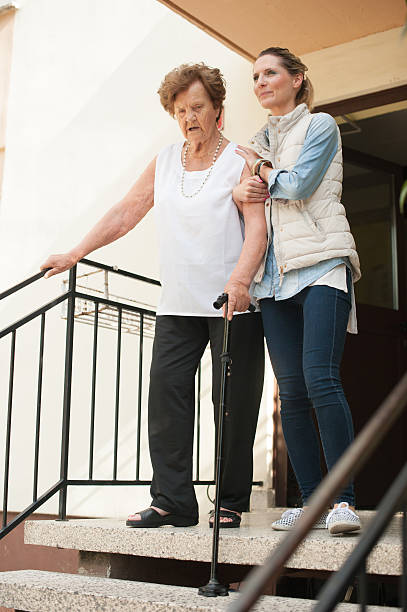 istock Helping an Elderly Woman Walk Downstairs 638057762