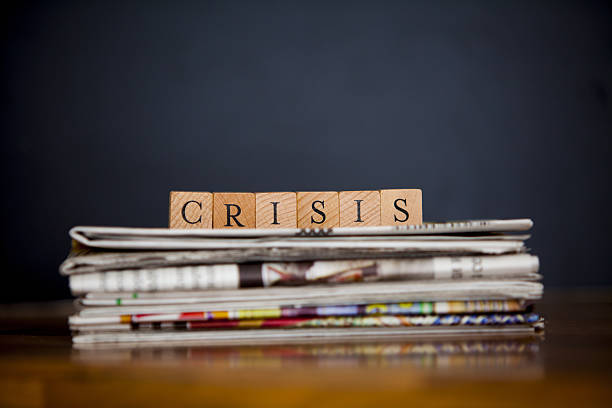 crisis stack of newspapers and article writen with wooden blocks crisis stock pictures, royalty-free photos & images