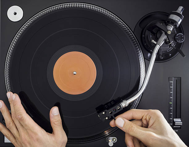 istock DJ Turntable, Hands placing Tonearm on Vinyl Record, Top View 638063200