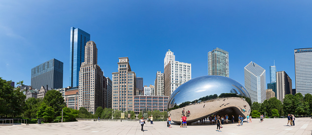 Chicago, Illinois, United States - June 14, 2016. Cloud Gate sculpture in Millenium park. One of the most unique and interesting sculptures. Author Anish Kapoor. Panorama cityscape.