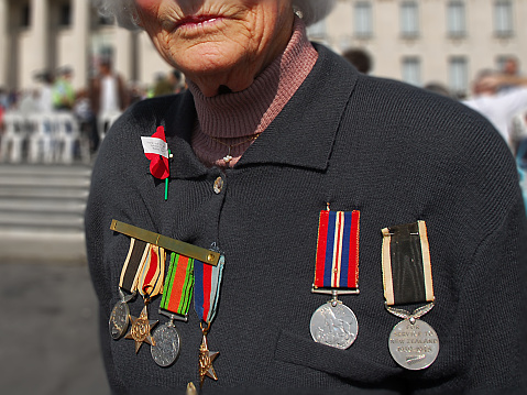 Auckland, New Zealand - April 25, 2007: A senior woman displays war medals during an ANZAC Day memorial service for those killed during war.  ANZAC Day is recognised in New Zealand every year on April 25.