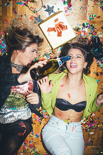 Party Two Girls laying on the floor full of confetti 3686 stock pictures, royalty-free photos & images