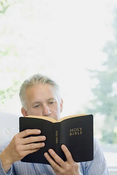 Photo of Man reading holy bible book