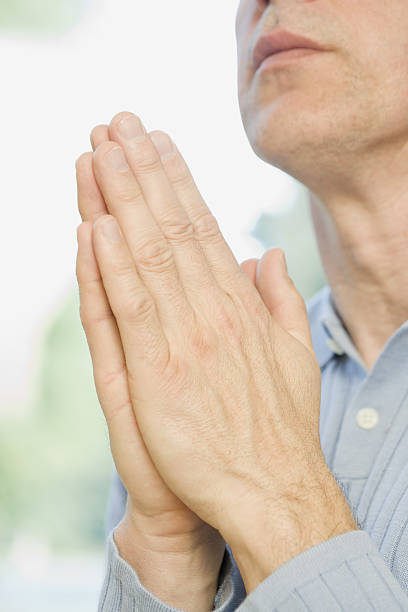 istock Man praying with hands together 638072160