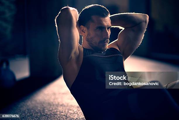 Man Doing Situps Stock Photo - Download Image Now - Dark, Health Club, Effort