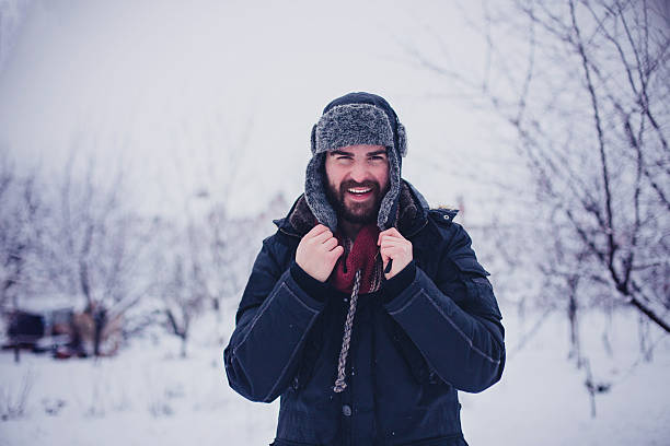 istock Young bearded man in warm jacket standing and smiling 638078256