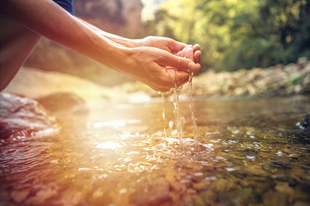 menschliche hand gezappt, um frisches wasser aus dem fluss zu fangen - catch light stock-fotos und bilder