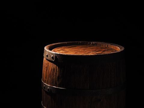 Old barrel with cognac on wooden backgroun.