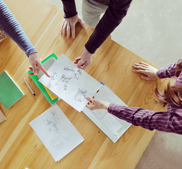 Overhead view of designers collaborating at table in studio