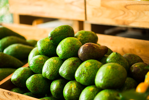 Pile of fresh ripe avocados in wooden box