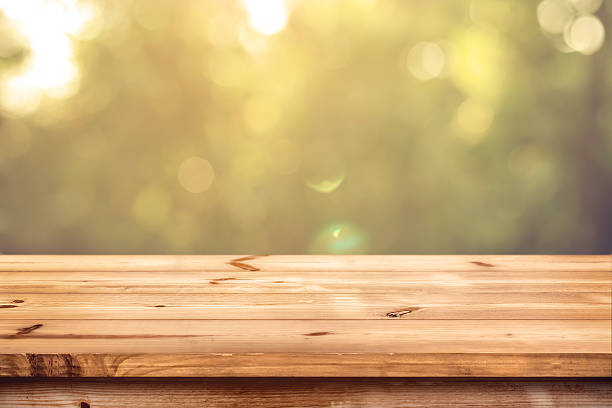 wood table in park Top of wood table with blurred bokeh nature background - Empty ready for your product display montage. wood table stock pictures, royalty-free photos & images