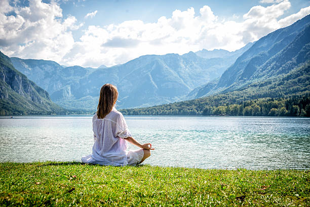 istock Woman meditating at the lake 638093188
