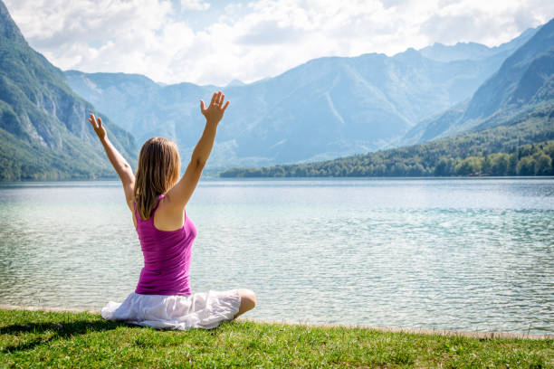 istock Woman meditating at the lake 638093668