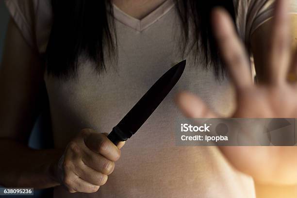 Photo libre de droit de Femme Tenant Un Couteau À La Main Tout En Se Défendant banque d'images et plus d'images libres de droit de Couteau