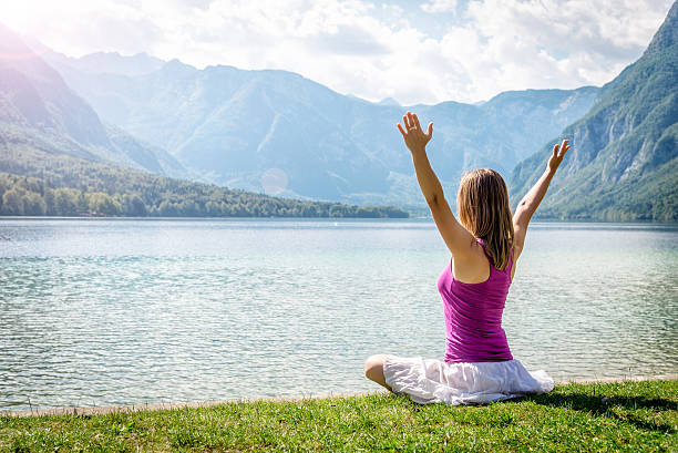 istock Woman meditating at the lake 638096552