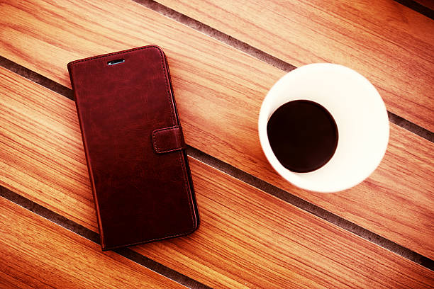 istock Wooden table in cafe with cell phone and coffee background 638098534