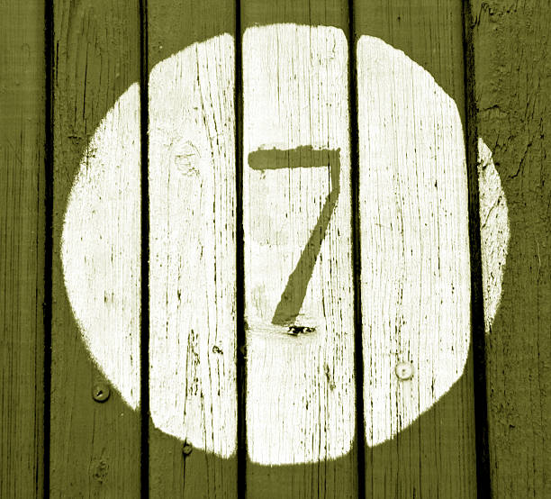 istock Number seven on yellow wooden wall 638100784
