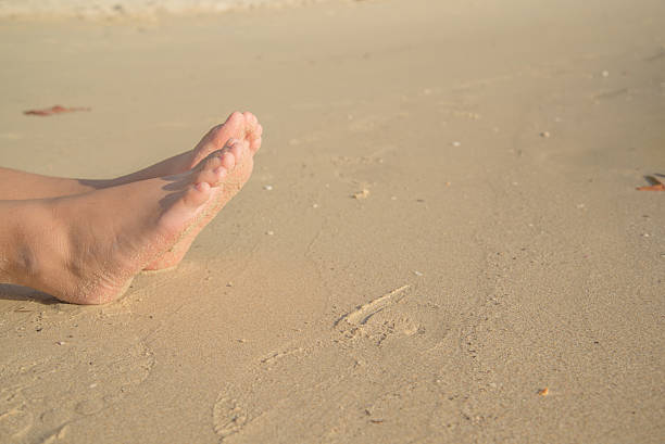 istock feets with sand of lady sit on the beach 638101038