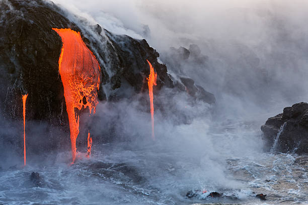 Molten Lava dripping into the ocean stock photo