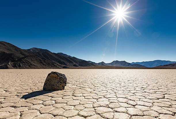 Lone Sailing rock at Racetrack Playa A lone "sailing rock" sits basking in the bright unrelenting sun at Racetrack Playa in Death Valley National Park, California death valley desert photos stock pictures, royalty-free photos & images