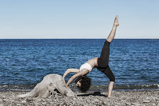 Woman doing yoga exercises at the beach