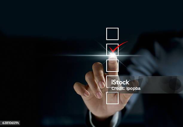 Businessman Checking Mark On Checklist With A Red Marker Stock Photo - Download Image Now