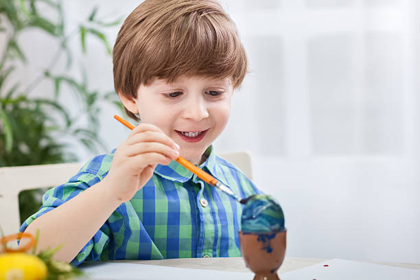 istock Little child painting eggs for easter 638107262