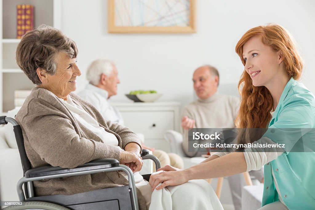 Nurse taking care of woman Nurse taking care of senior woman on wheelchair Community Outreach Stock Photo