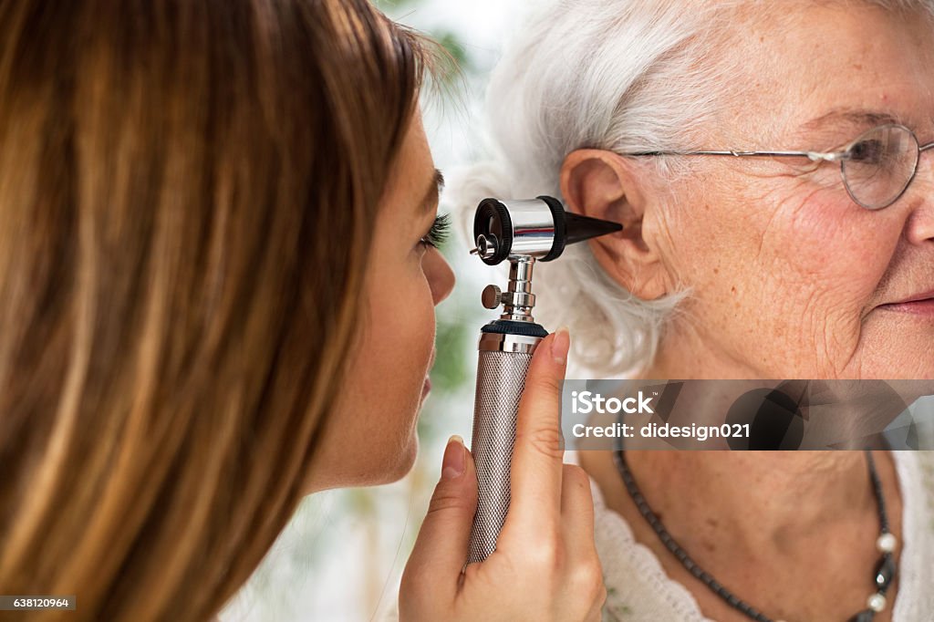 Arzt hält Otoscope und Untersuchung Ohr der Seniorin - Lizenzfrei HNO-Untersuchung Stock-Foto