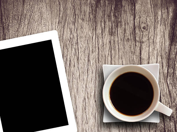 istock Coffee cup and tablet on wooden table background textured.Technology concept. 638124620