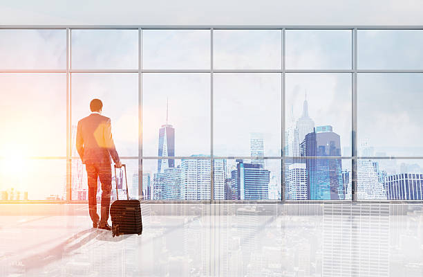 istock African man with suitcase looking at city from office 638126340